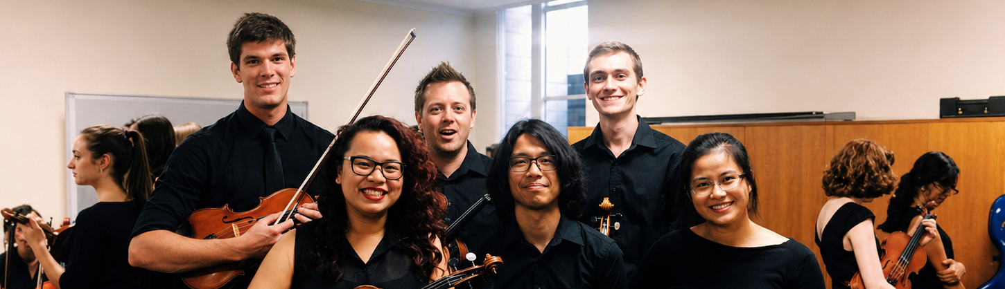 A young group of viola players smiling for the camera backstage before a concert.